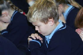 A child prays in St. Luke's school